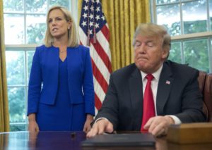 President Donald Trump, right, listens as Homeland Security Secretary Kirstjen Nielsen, left, addresses members of the media before Trump signs an executive order to end family separations at the border, during an event in the Oval Office of the White House in Washington, Wednesday, June 20, 2018. (AP Photo/Pablo Martinez Monsivais)