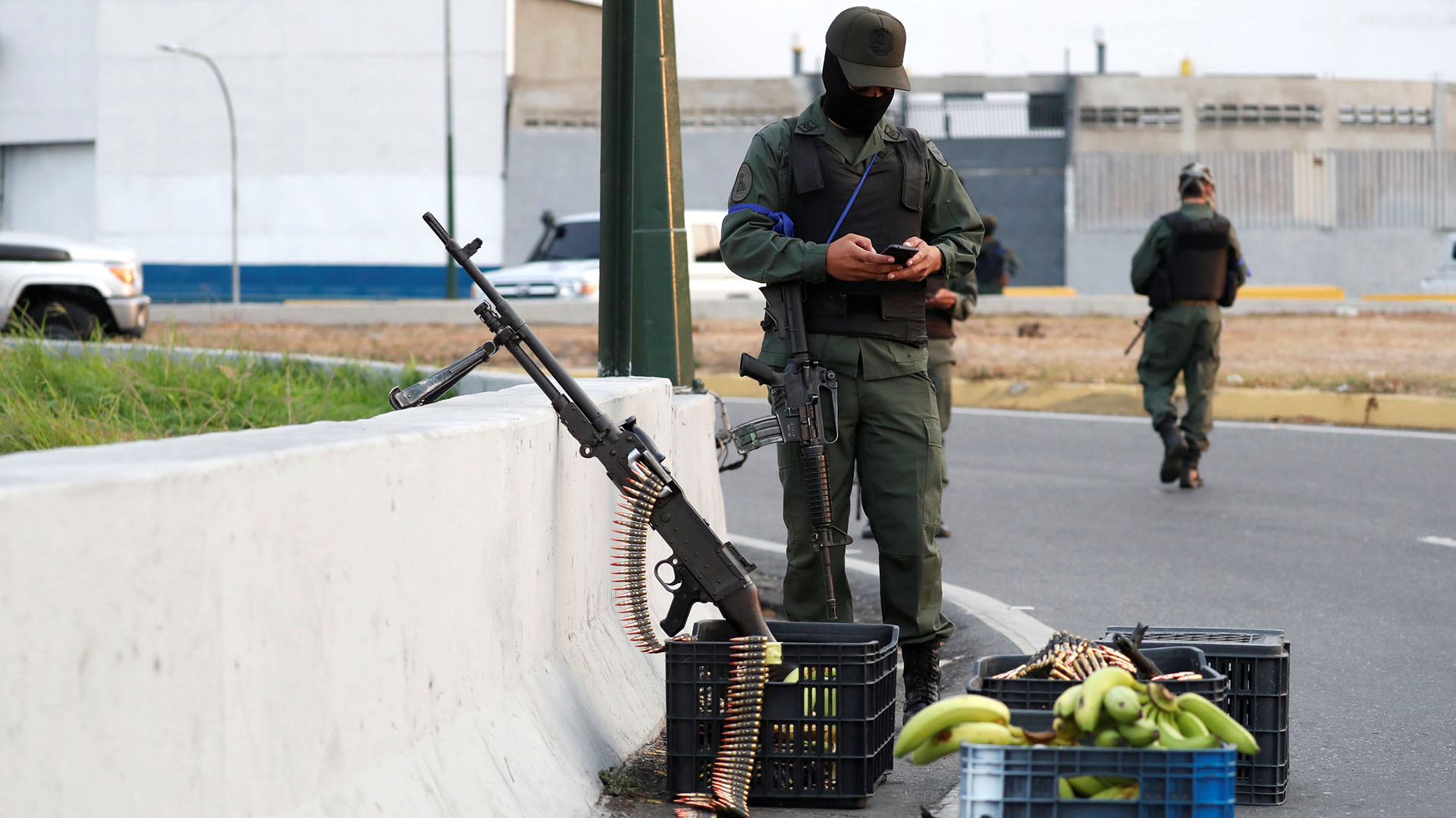A military member uses his phone near the Generalisimo Francisco de Miranda Airbase in Caracas